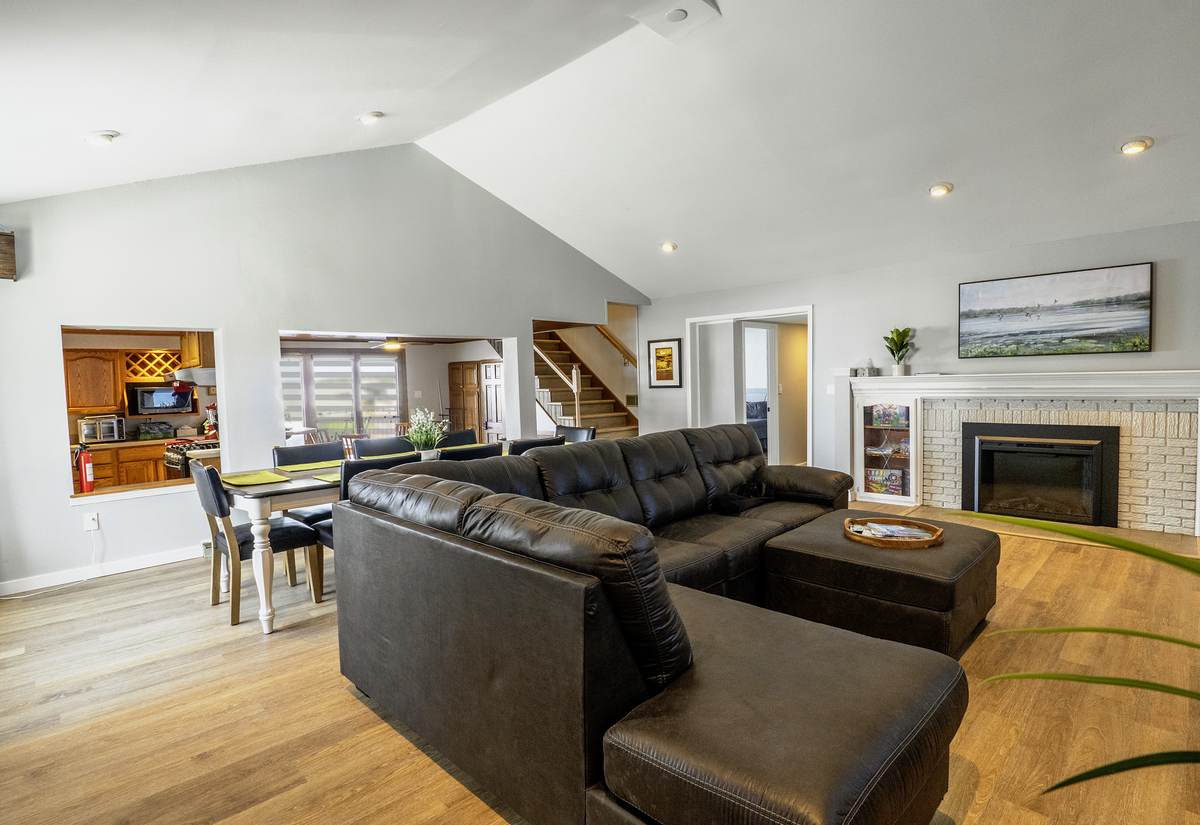 The open main floor from the front door: sectional, dining, kitchen