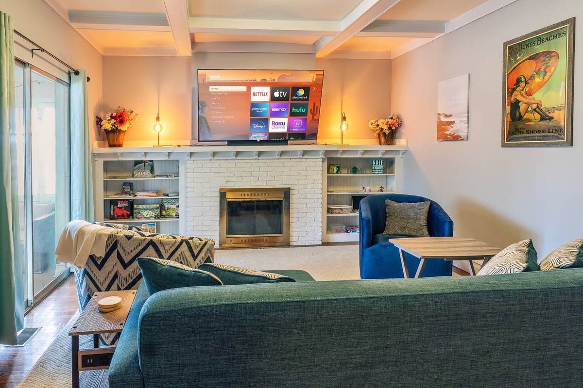 Living room: sofa, swivel chairs, and the 70-inch Roku TV